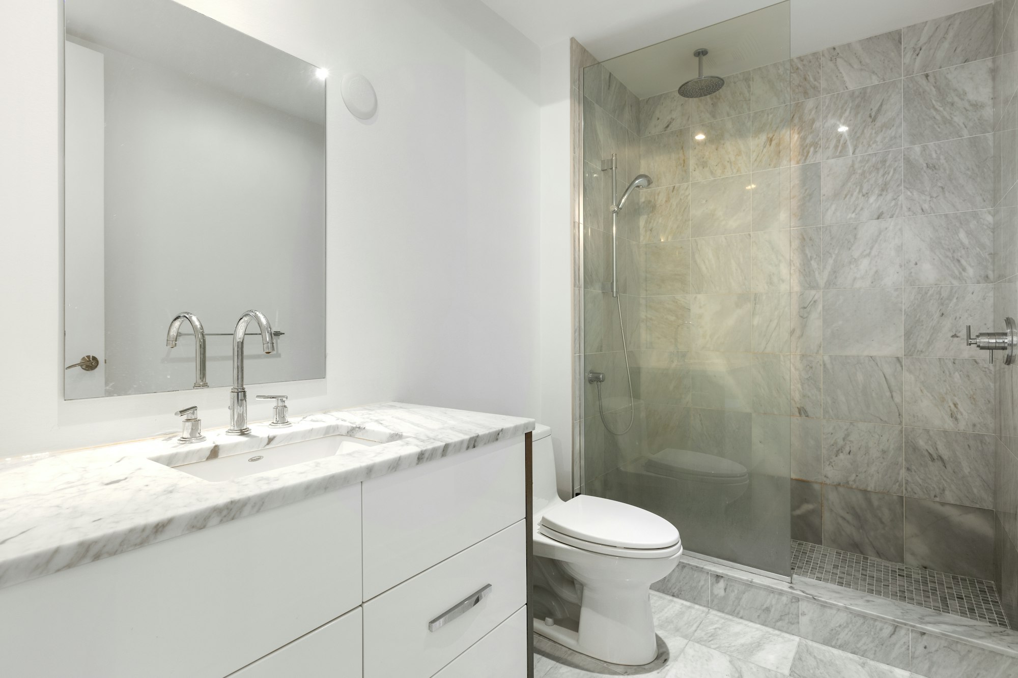 Baño con pavimento y paredes de piedra gris