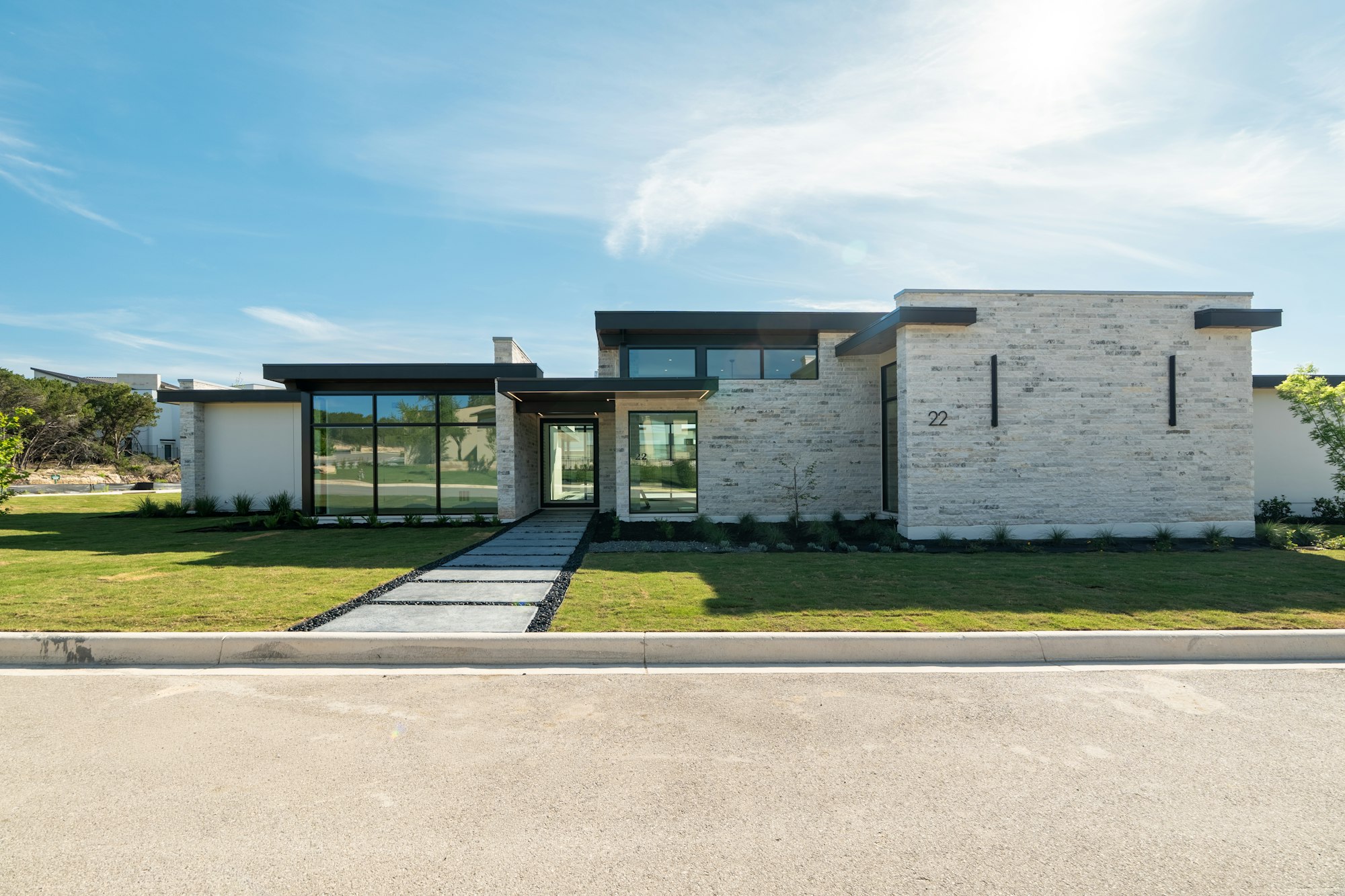 Casa moderna de una planta con fachada de piedra clara