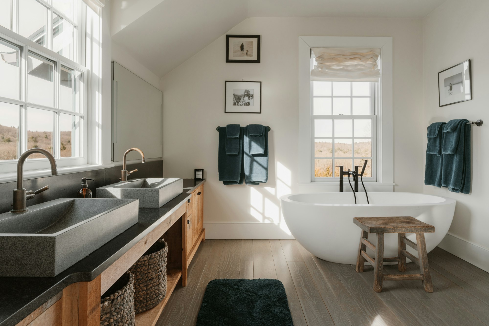 Baño luminoso con bañera exenta y lavabos de piedra